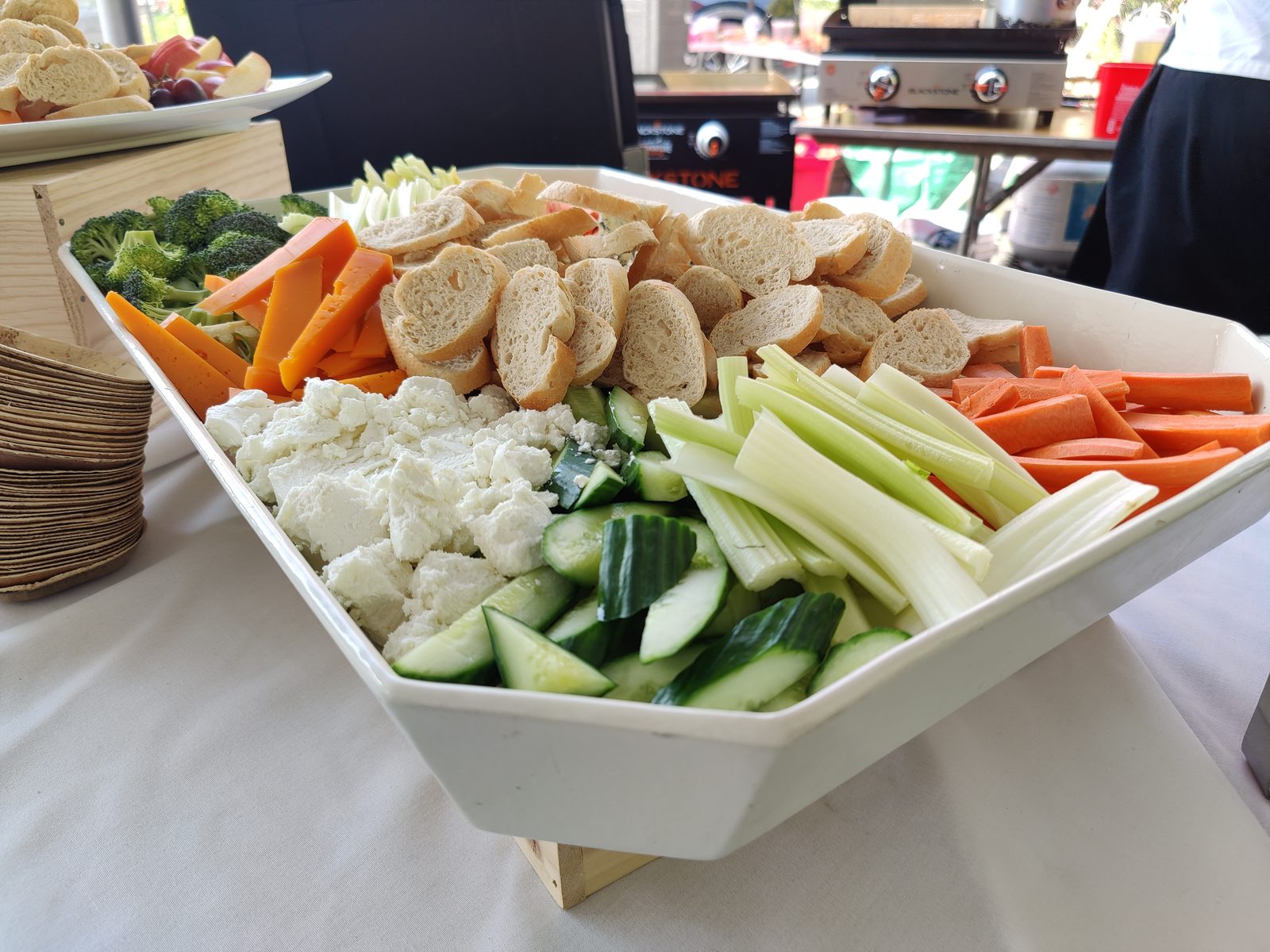 A crudité and cheese platter with fresh-cut vegetables, crackers, and crumbled cheese