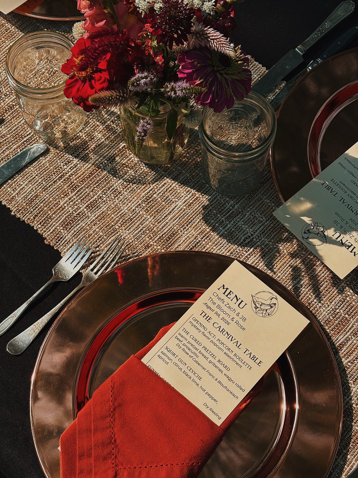 An event place setting with a copper charger, cloth napkin, and printed menu card