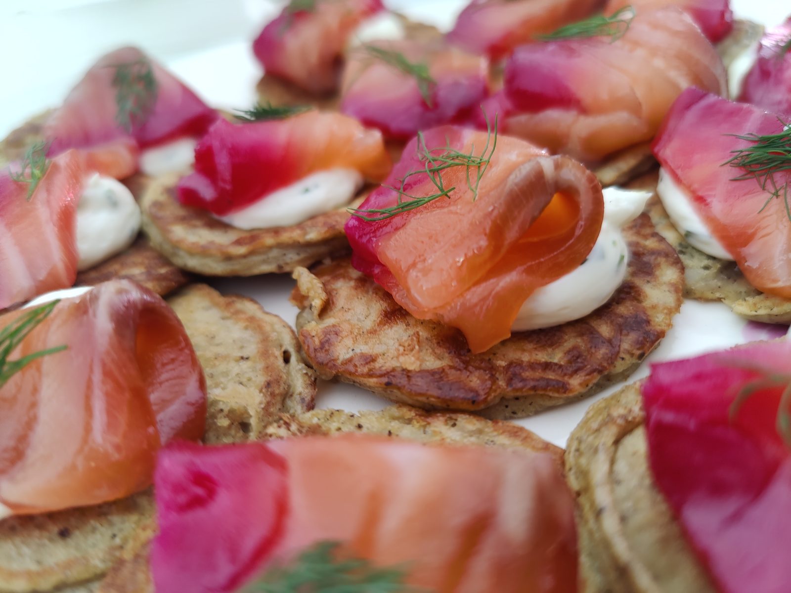 Blini canapés topped with smoked lox, dill, and crème fraîche