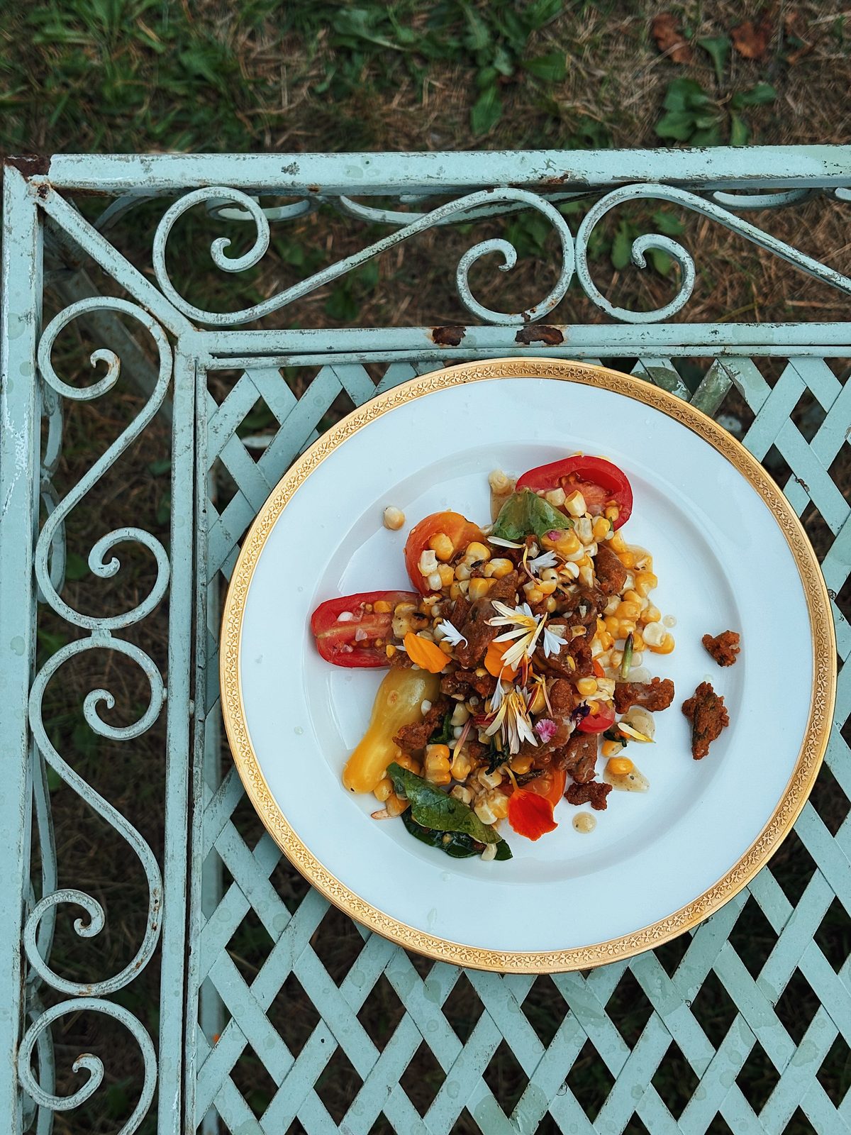 Overhead view of a plated seasonal dish on a gold-rimmed plate