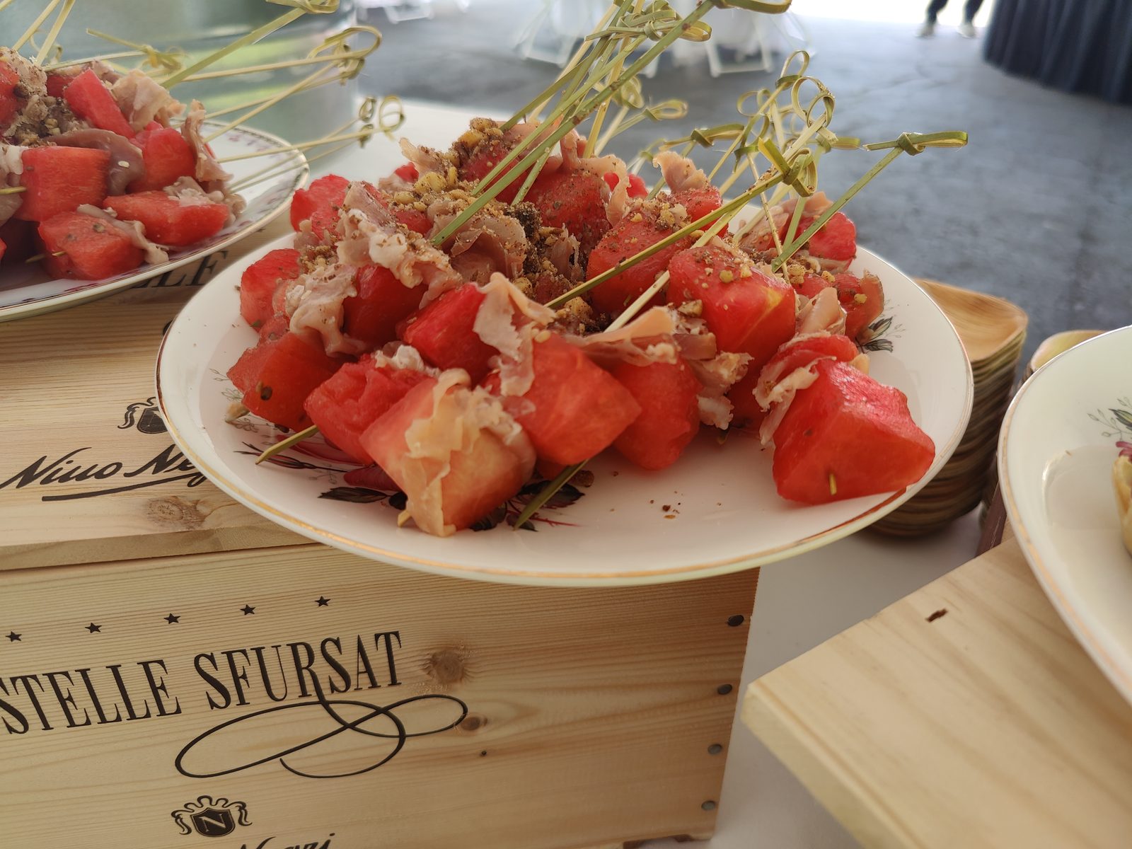 Watermelon and prosciutto skewers stacked on a serving board
